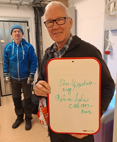 Björn von Sydow på besök på KA2, med skylt i handen där det står "Stor uppskattning" samt hans namn och att han var försvarsminister mellan åren 1997 - 2002